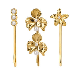 Vue détaillée de trois barrettes dorées à fleurs avec des perles élégantes