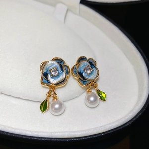 Detailed macro shot of vintage blue enamel flower earring with pearl and diamond center