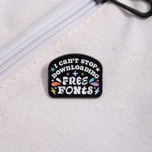 Detail of funny enamel pin on white canvas bag with quote about free fonts