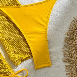 Detail of bright yellow bikini bottoms with matching knit mesh cover-up fabric texture