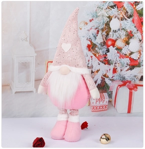 Pink Christmas gnome plush toy with knitted hat and long beard in a festive scene