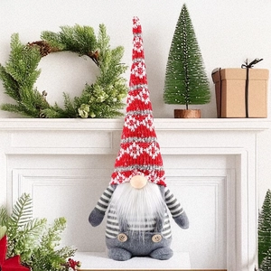 Détail d'un gnome de Noël avec bonnet rouge et salopette grise sur une cheminée