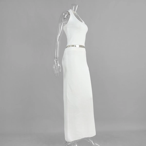 Detail of white ribbed knit two-piece set with sleeveless top and maxi skirt with silver belt