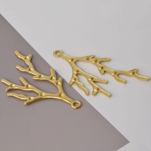 Macro detail of two golden 304 stainless steel branch charms for DIY jewelry making