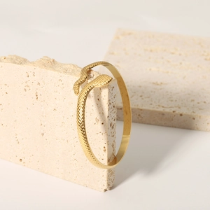 Macro detail of snake-shaped 18K gold-plated stainless steel cuff with scale texture