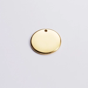 Close-up of polished 18k gold-plated stainless steel round pendant blank with hole