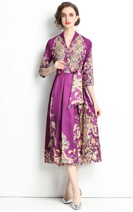 Detail of elegant purple V-neck floral dress featuring waist tie and silky texture