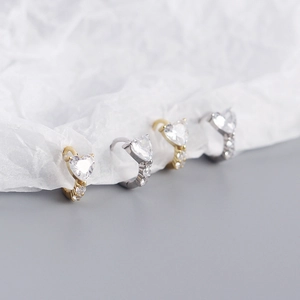 Macro shot of silver and gold heart-shaped zircon earrings with pavé setting detail