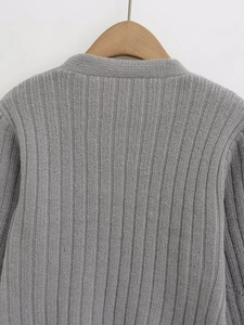 Close-up of grey ribbed knit texture and neckline on a wooden hanger with clean background