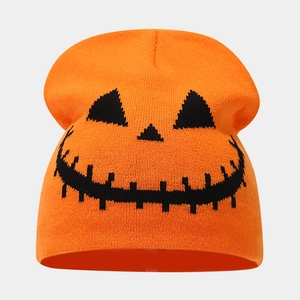 Detailed close-up of orange knitted beanie featuring black Halloween pumpkin face patterns