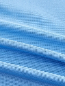 Détail macro du tissu en maille piquée bleu ciel respirant pour polo décontracté