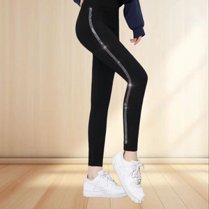 Detail of black seamless leggings featuring sparkling rhinestone side stripes on legs