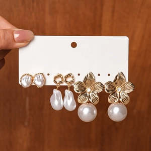 Detailed set of floral and pearl earrings with golden metallic finish and crystals