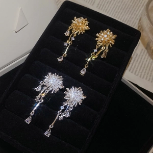 Detailed macro of gold and silver firework pearl earrings with zircon water drop pendants