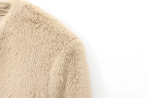 Close-up detail of soft cream faux fur texture on the collar and shoulder area