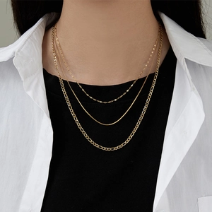 Golden multi-layer titanium steel necklace set with three different chain styles on model