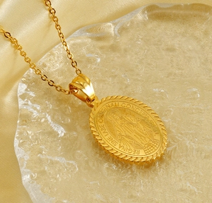 Close-up of golden Virgin Mary oval pendant with religious Latin engraving and rope texture