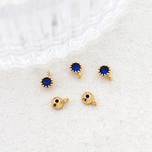 Close-up of gold-plated pendant charms with blue round zircon for DIY jewelry making