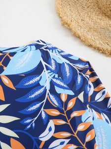 Détail à plat du maillot de bain à manches longues avec imprimé de feuilles tropicales
