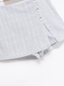 Gros plan détaillé du tissu rayé bleu et blanc avec trois boutons décoratifs blancs