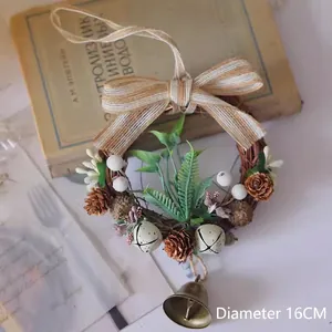 Détail d'une couronne de Noël de 16cm avec pommes de pin, baies et petite cloche