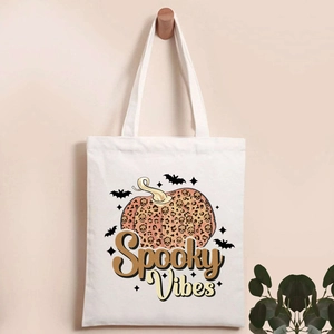 Close-up of canvas tote bag featuring spooky vibes pumpkin and leopard print design