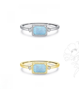Detail view of gold and silver S925 rings with blue opal and side zircon accents
