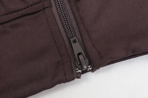 Detail of dark brown sports jacket zipper with premium knit fabric texture and high-end finish