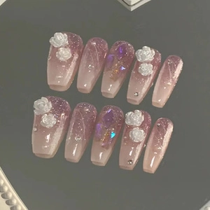 Detail of purple gradient press-on nails with 3D white roses and sparkling sequins