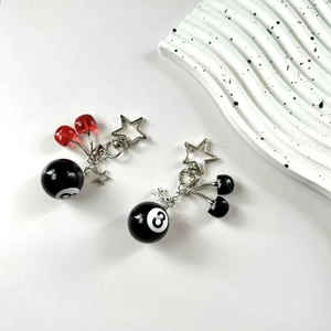 Detail of handmade cherry pendants and black number 8 ball keychains with star charms
