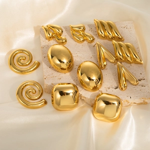 Minimalist gold geometric earrings collection with textured finish on silk background