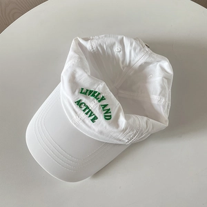 Detailed view of green LIVELY AND ACTIVE embroidery on a white nylon baseball cap