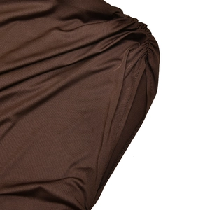 Gros plan sur le tissu en maille marron plissé montrant la texture et les coutures