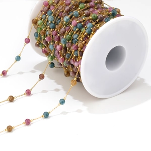 Detailed macro view of colorful bead chains on a roll for DIY jewelry making