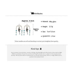 Macro detail of snake moon earrings with turquoise beads and glass tassel charms