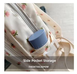 Detailed view of the floral backpack side pocket with a storage compartment and buckle