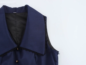 Vista dettagliata del gilet blu navy con bordo in pizzo e bottoni in metallo dorato