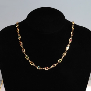 Detail of 18K gold-plated copper necklace with colorful square zircons on a black bust