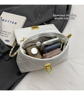 Internal view of a white quilted chain bag showing capacity for phone and cosmetics