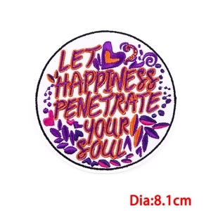 Detail of round 8.1cm embroidered patch with inspirational quote and colorful floral patterns