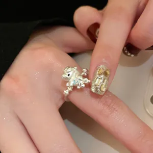 Gros plan d'une bague licorne en argent avec une pierre bleue portée au doigt