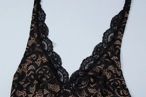 Détail en gros plan de l'encolure en dentelle florale noire et des bords festonnés