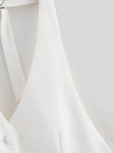 Détail du haut dos nu blanc montrant la texture du tissu sergé et le bouton assorti