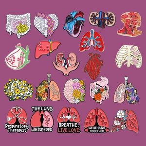 Anatomical organ enamel pins including lungs and heart on a purple background