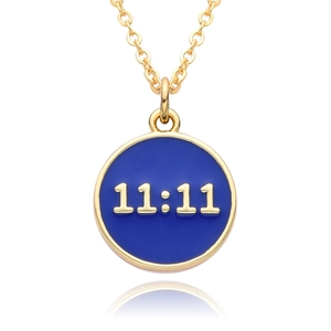 Detail of round golden pendant with blue enamel and 11:11 angel number design