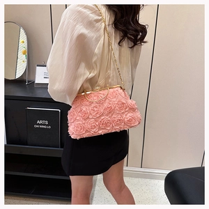 Detail of pink fabric rose floral evening clutch with gold chain and jewel clasp