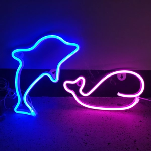 Detailed view of LED dolphin and whale neon signs showing glowing colors and wall mounts