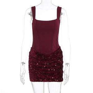 Detail of burgundy corset dress featuring a sequined mini skirt and vertical bodice seams