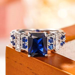 Macro detail of silver square ring with large blue gemstone and four-prong setting