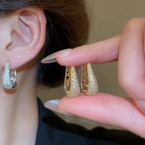Gros plan sur les créoles en U avec zircons micro-pavés en finitions dorée et argentée
